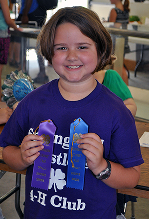 4-H youth (girl) showing off her ribbons
