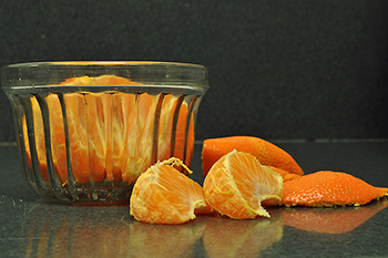 Clementine citrus fruit pealed laying on counter and in glass bowl
