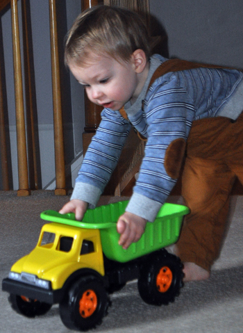 Baby playing with plastic dump truck