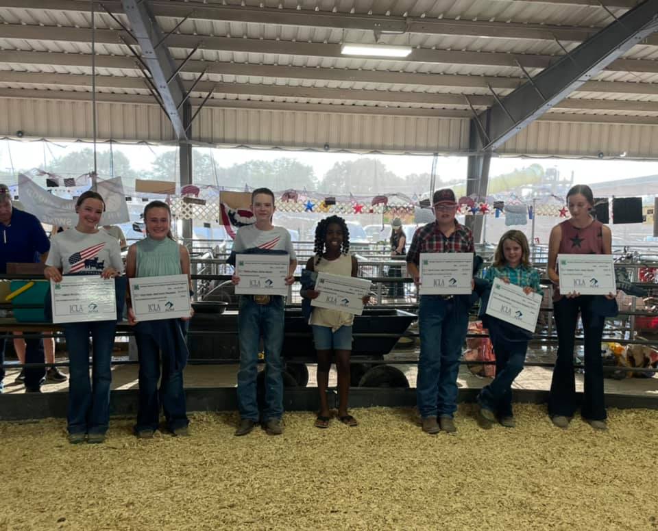 kids lined up holding awarded checks 