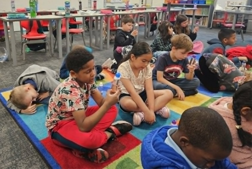 Students practice mindful eating; describing how their apples taste, feel, sound, smell and look before eating. 