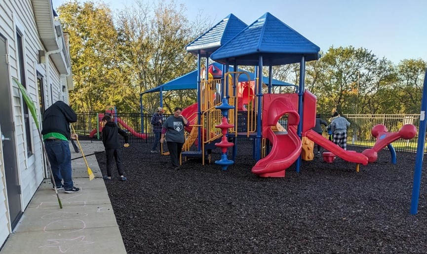sweeping mulch around a playground