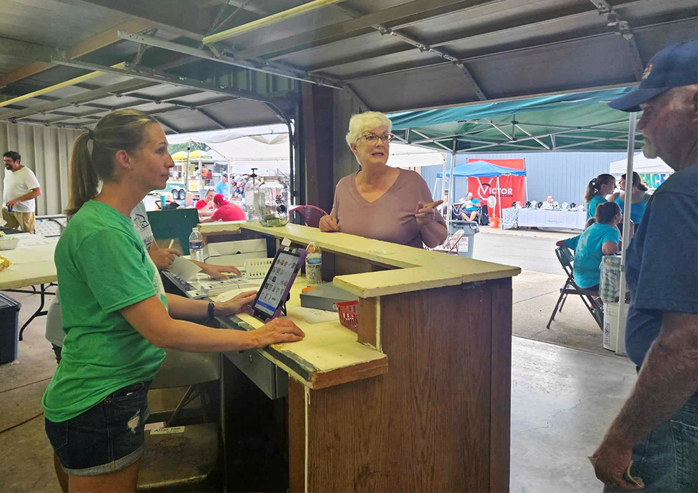 people at a food stand 4h