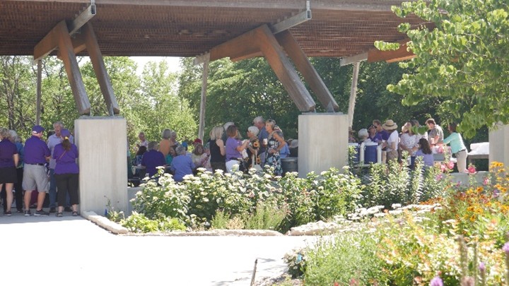 Volunteers enjoying a gathering under a pavilion 