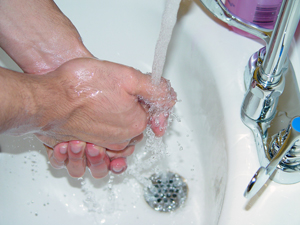 Washing hands under a sink.