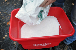 Fertilizer being poured into a application spreader.
