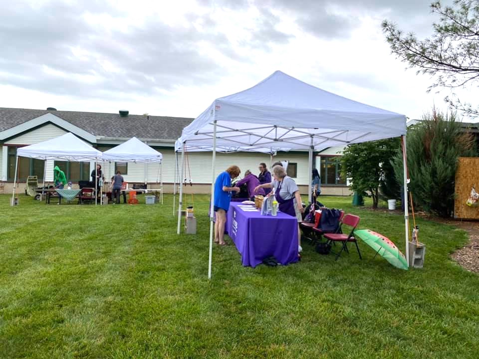 Women serve food behind table
